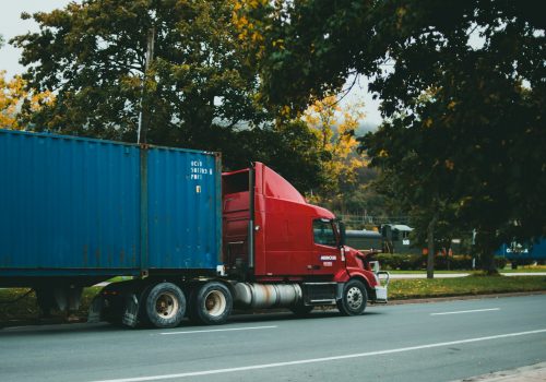a red semi truck driving down a street