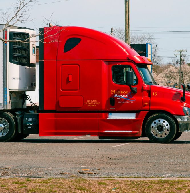red and white truck on road during daytime